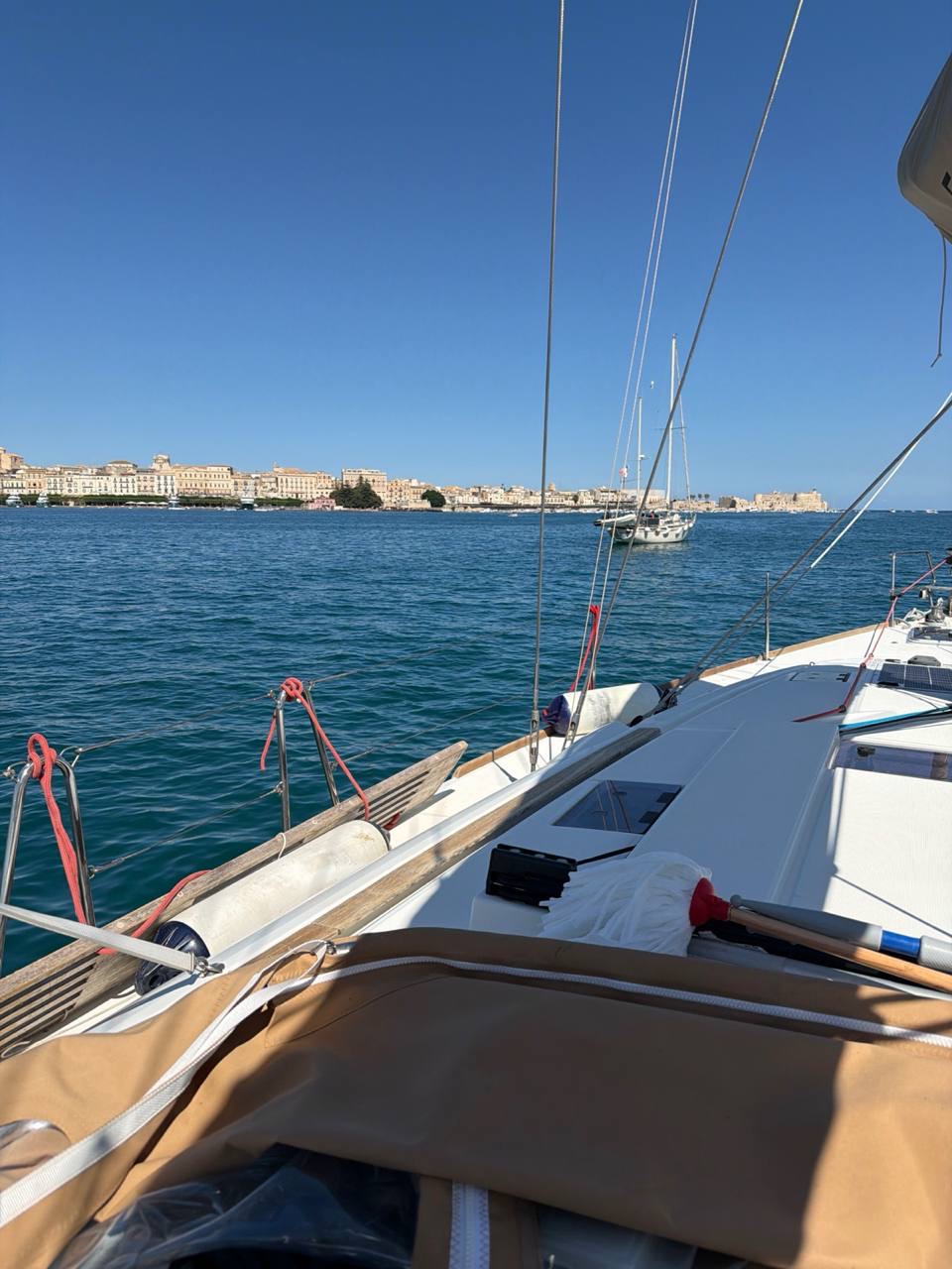 View from Everything Zen's foredeck across Porto Grande to the Ortigia waterfront, with other yachts at anchor